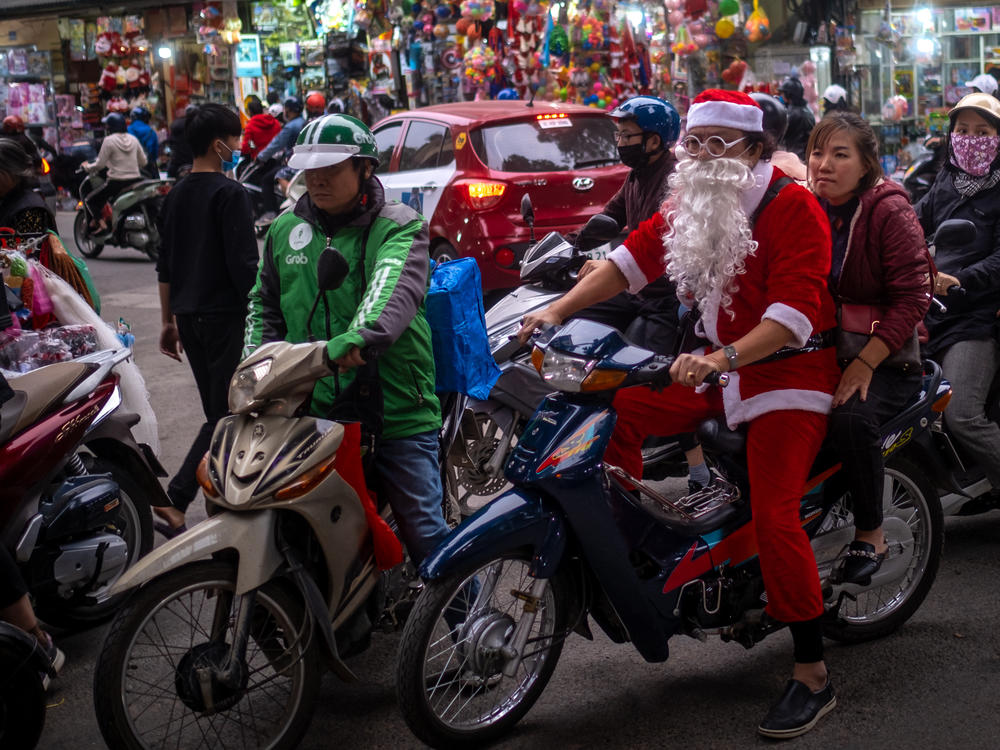 A man in a Santa Claus costume rides a motorbike in the Old Quarter on Dec. 24, 2020, in Hanoi, Vietnam.