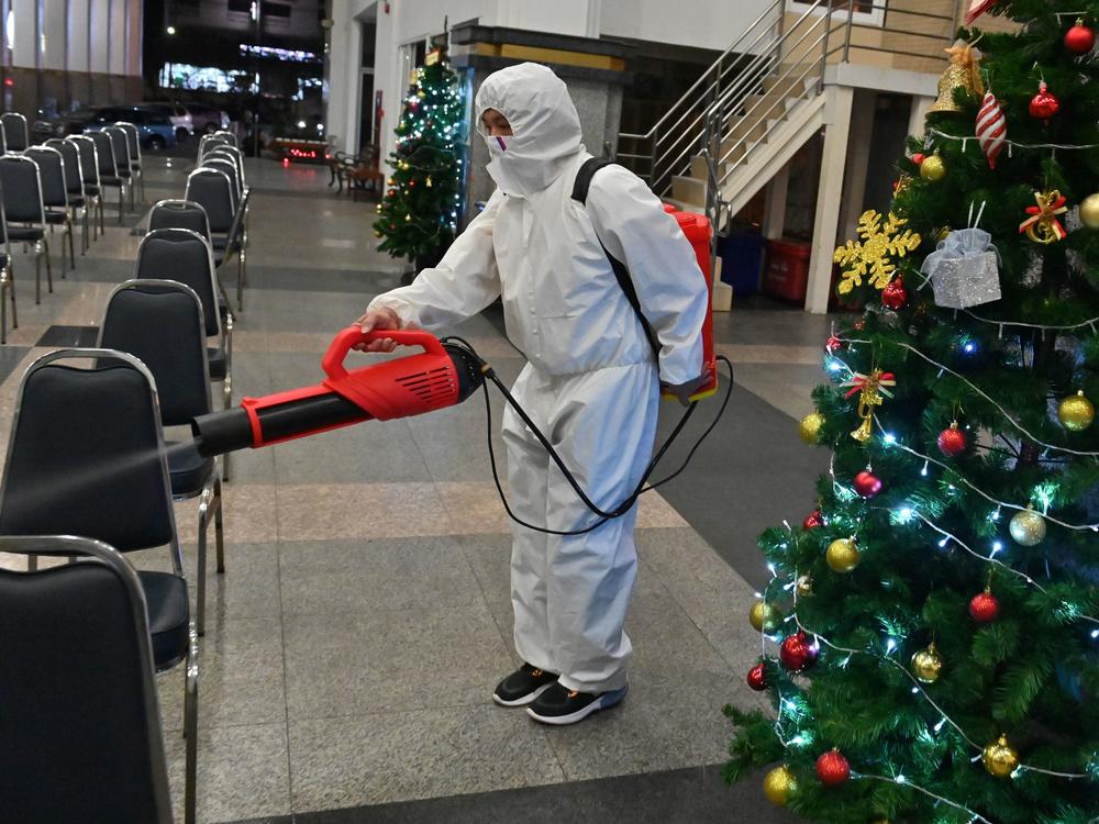 A worker wearing personal protective equipment disinfects the Holy Redeemer Church in Bangkok after a Christmas Eve mass. Thailand is one of many countries now seeing a surge in cases.