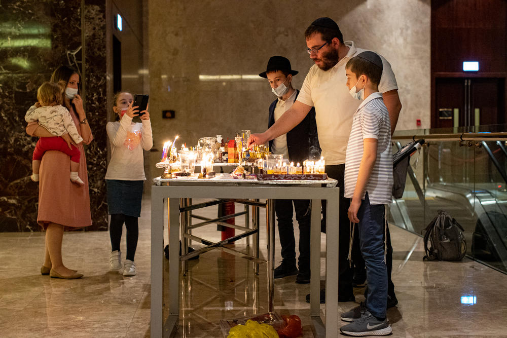 An Israeli family lights menorahs during a Hanukkah celebration at the Conrad Hotel in Dubai on Dec. 16.