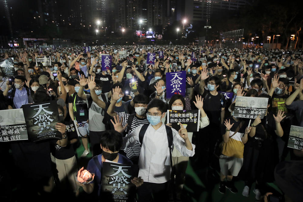 After Hong Kong's huge pro-democracy demonstrations in 2019, the Chinese government imposed a new security law this year. Still, protests continued. At a June 4 vigil for victims of the 1989 Tiananmen Square massacre, demonstrators gesture with five fingers, signifying 