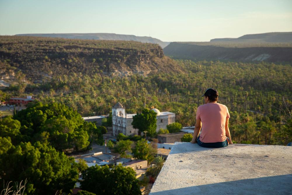 After a hike up to the local water tower, Hiro looks out over the downtown plaza and mission of San Ignacio. His family has been here for generations and were some of the first immigrants to the area following the building of the mission.