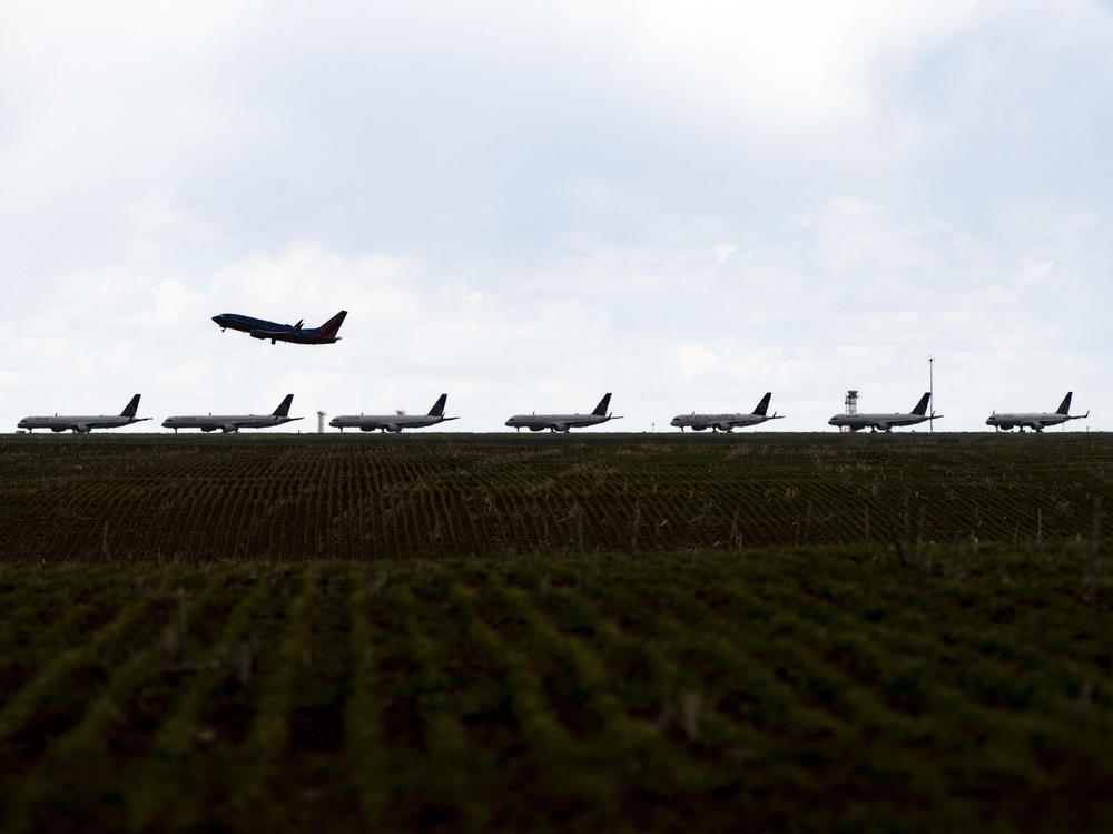 A Southwest Airlines flight takes off as United Airlines planes sit parked on a runway at Denver International Airport in April.
