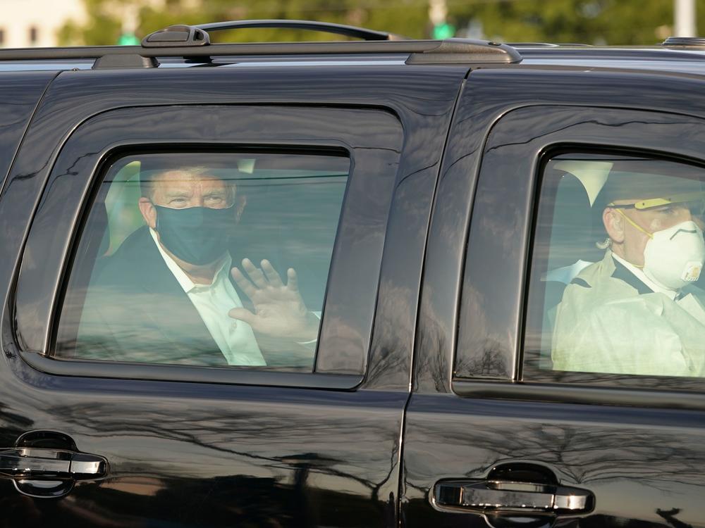 Dr. James Phillips is no longer working at Walter Reed National Military Medical Center, months after criticizing President Trump's flouting of coronavirus safety guidelines. Here, Trump waves to supporters from an SUV in October as he was driven outside the facility in Bethesda, Md.