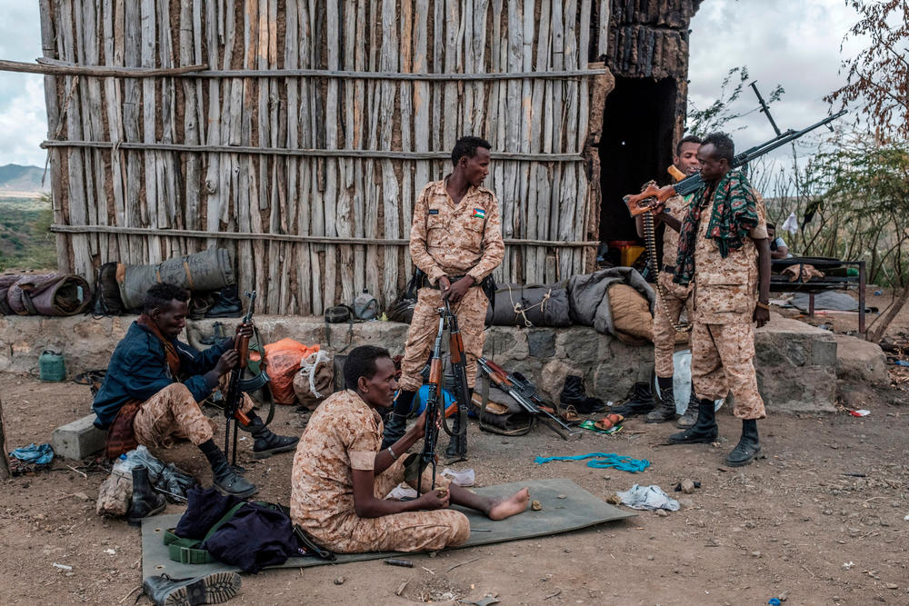 In November, Ethiopian government forces began fighting a powerful regional government in the country's northern Tigray region, displacing thousands. Members of the Afar Special Forces prepare their weapons on the outskirts of the village of Bisober in the Tigray region on Dec. 9. Several houses in the village were damaged during fighting between Tigrayan forces and the Ethiopian military.