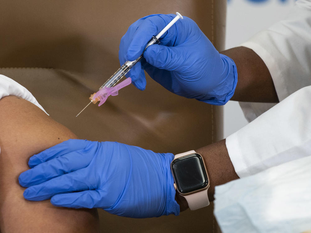 Arlene Ramirez receives the Moderna COVID-19 vaccine last week at Northwell Health's Long Island Jewish Valley Stream hospital in New York. Health care workers across the country have started receiving COVID-19 vaccines, but doctors and nurses at some hospitals say vaccine distribution has been chaotic.