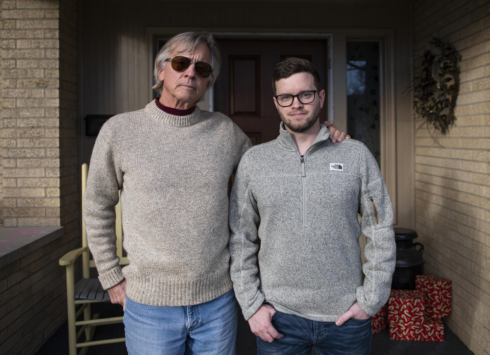 Scott Williams (left) and his son, Andy Williams, stand outside Scott Williams' home in Lebanon, Ind. Scott Williams lost his wife, Debbie, in April to hypothyroidism. The family has yet to have a proper funeral due to the pandemic.