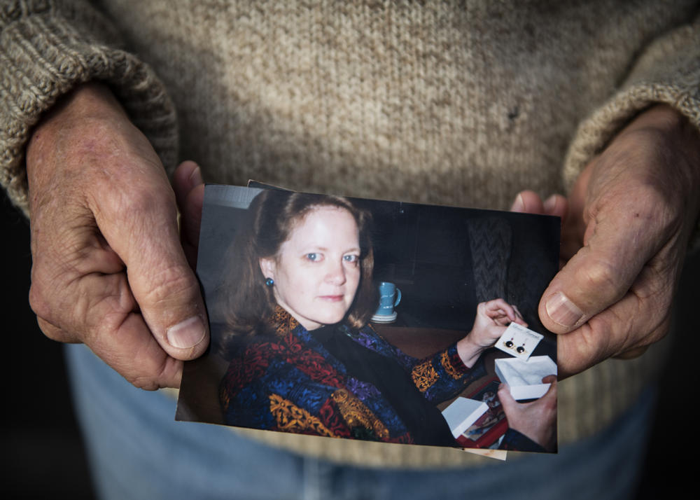 Scott Williams holds a favorite photo of his late wife, Debbie, outside his home in Lebanon, Ind. Debbie died in April of hypothyroidism. The family has yet to have a proper funeral due to the pandemic.