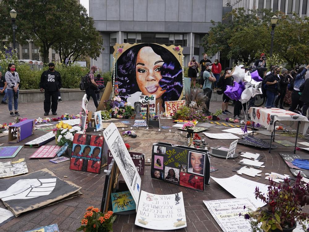 Two more Louisville police officers have been told they will be fired in the wake of the death of Breonna Taylor, whose image is seen in a memorial in September.