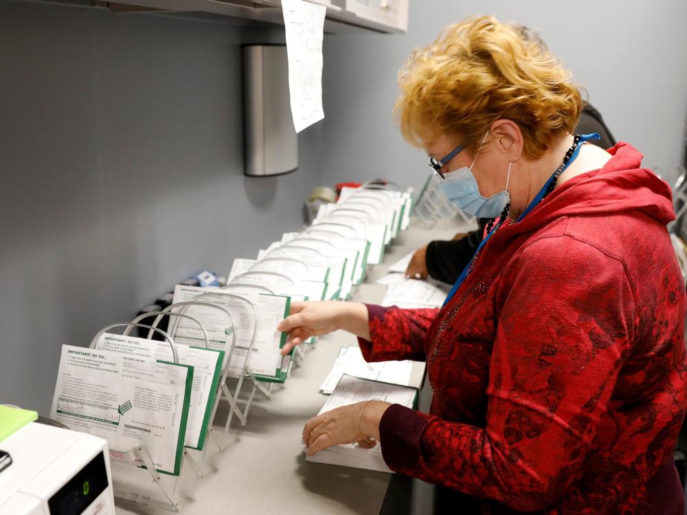 A West Bloomfield, Mich., Clerk's Office employee sorts absentee ballots by the precinct and ballot number on Oct. 31.