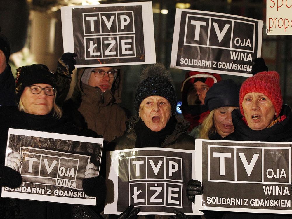 Protesters hold signs demanding the resignation of TVP chairman Jacek Kurski in Warsaw, Poland, on Jan. 26, 2019, blaming the atmosphere created by the government-controlled broadcaster's messaging for the  killing of of Gdansk Mayor Pawel Adamowicz.