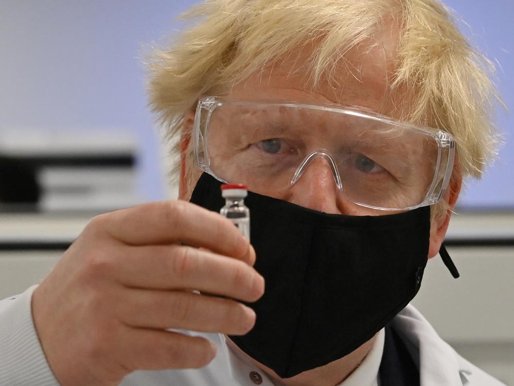 U.K. Prime Minister Boris Johnson looks at the newly authorized AstraZeneca/Oxford University COVID-19 vaccine.