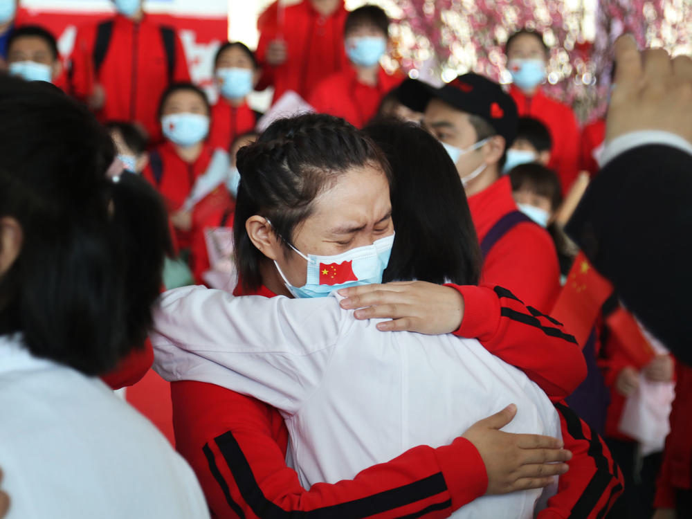 Health workers from Tongji Hospital in Wuhan, China, share an emotional embrace with their peers from a hospital in Jilin province at the Tianhe Airport. Colleagues who worked on the front lines together bid farewell as Wuhan lifted its coronavirus lockdown in April.
