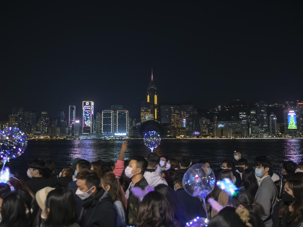 A crowd walks through Hong Kong's Victoria Harbor, a spot usually dedicated to larger New Year's celebrations, including fireworks, which were canceled this time.
