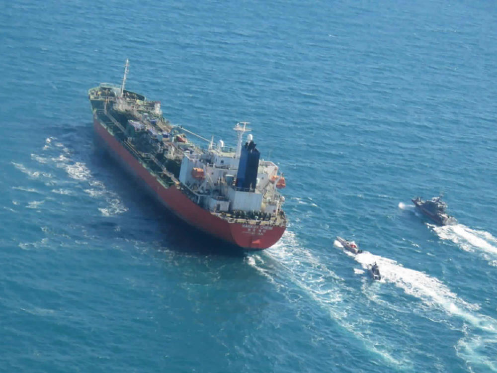 A seized South Korean-flagged tanker is escorted by Iranian Revolutionary Guard boats in the Persian Gulf. This comes as Tehran is enriching nuclear fuel to 20% purity.