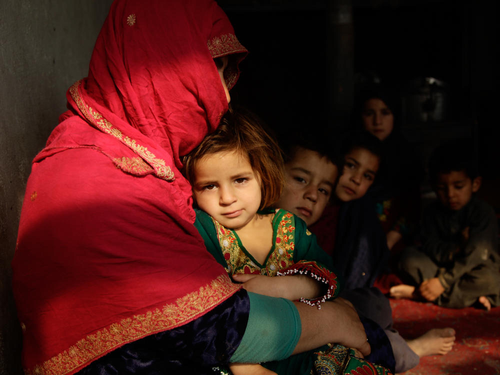 Shaista sits in her tiny home on the outskirts of Kabul. Her youngest, a 3-year-old girl, sits on her lap; some of her other seven children sit beside her. Behind them, she is boiling a pot of water on the wood-burning stove. But she's told the children it is dinner, and she tells them, 