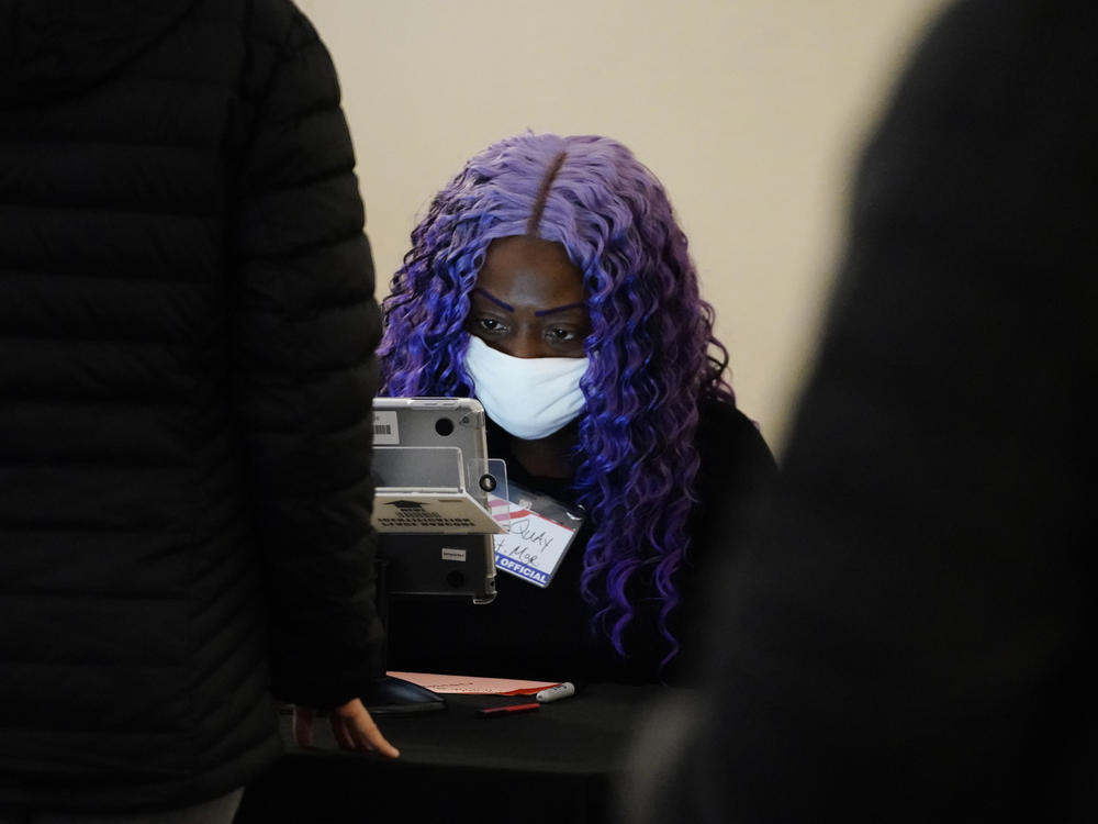 A poll worker registers voters before they cast their ballot in Georgia's Senate runoff elections Tuesday in Atlanta.