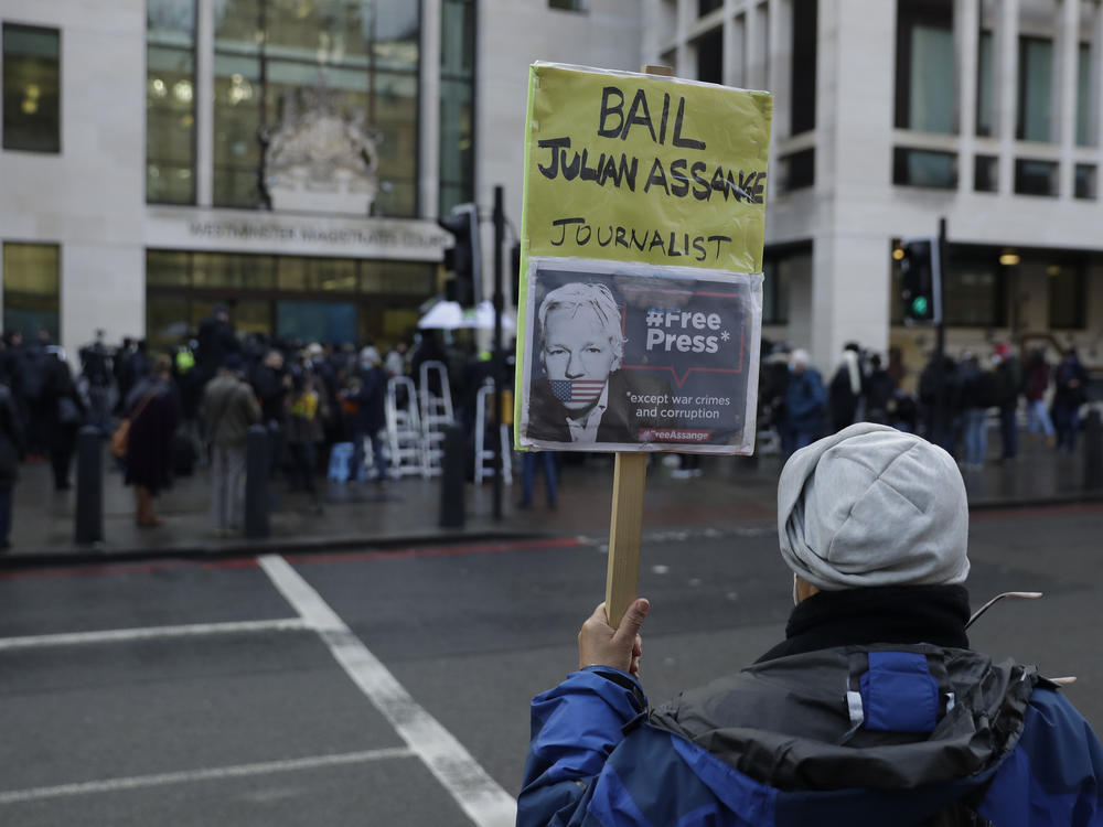 A Julian Assange supporter holds up a placard of the WikiLeaks founder outside Westminster Magistrates Court, the site of his bail hearing, in London on Wednesday.