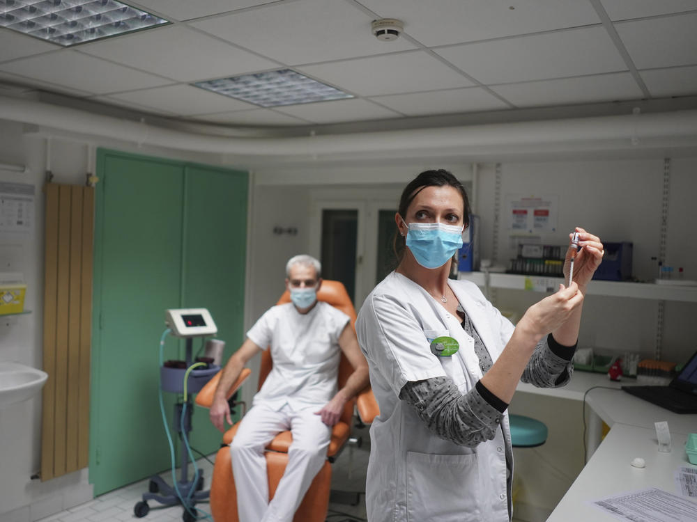 A nurse prepares to administer the Pfizer-BioNTech COVID-19 vaccine to Dr. Jean-Christophe Richard in La Croix-Rousse hospital, in Lyon, France, on Wednesday. Amid public outcry, France's health minister promised Tuesday an 
