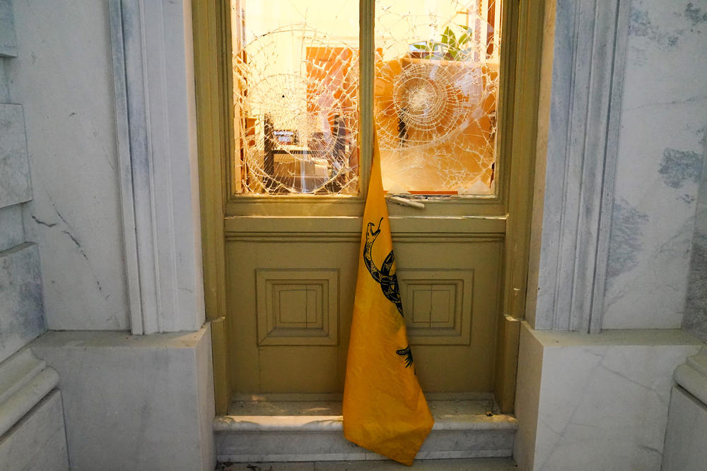 A flag hangs from broken windows at the Capitol.