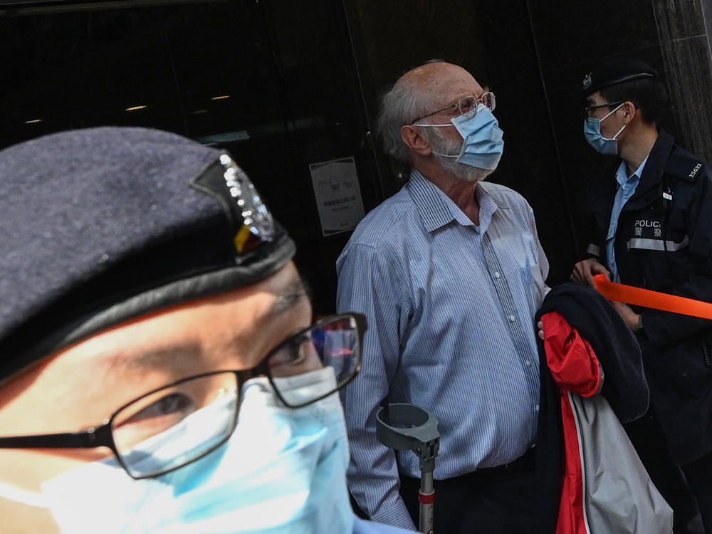 John Clancey, a U.S. attorney who is known for taking on human rights cases, is led away Wednesday by police after his arrest in Hong Kong under a new Beijing-imposed national security law.
