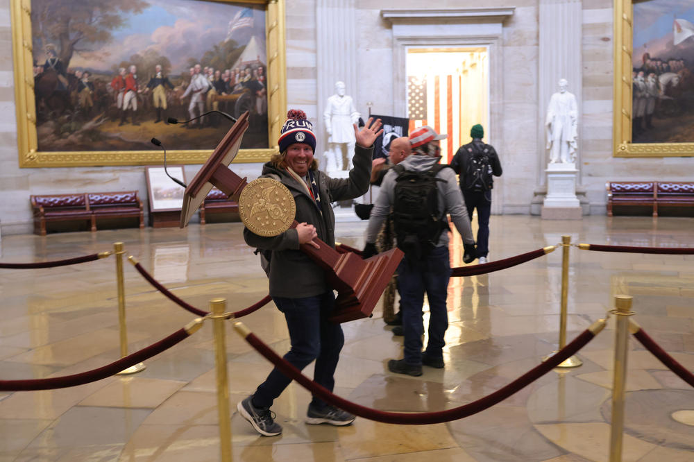 A rioter carries off a lectern inside the U.S. Capitol.