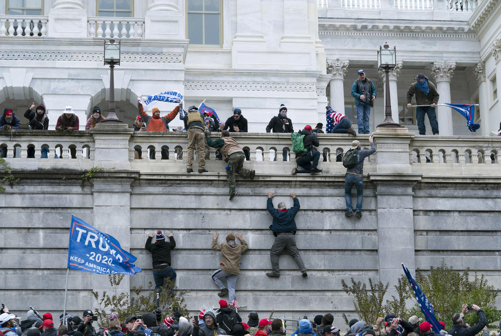 Rioters climb the west wall of the the U.S. Capitol. The rioters far outnumbered and swiftly overwhelmed the Capitol Police as they charged up the steps, smashed windows, broke into the Senate chamber and occupied offices.