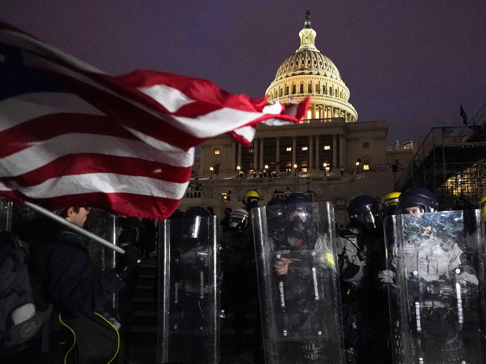 Police stand behind their shields outside the Capitol after a day of rioting on Wednesday.