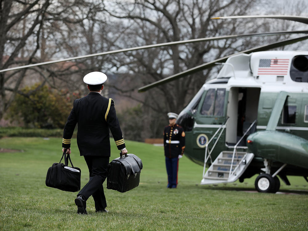 In March 2018, a White House military aide carries the 
