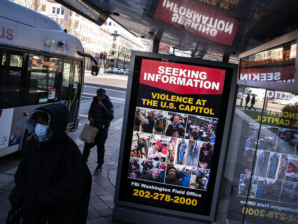 At a bus stop on Pennsylvania Avenue Northwest in Washington, D.C., a notice from the FBI seeks information about people pictured during the riot at the U.S. Capitol on Wednesday.
