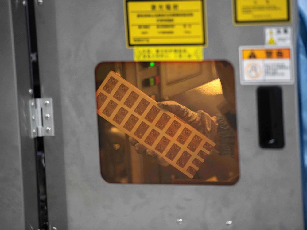 A worker is seen inside the production chain at Renesas Electronics, a semiconductor manufacturer, in Beijing on May 14, 2020. A global computer chip shortage is affecting automakers.