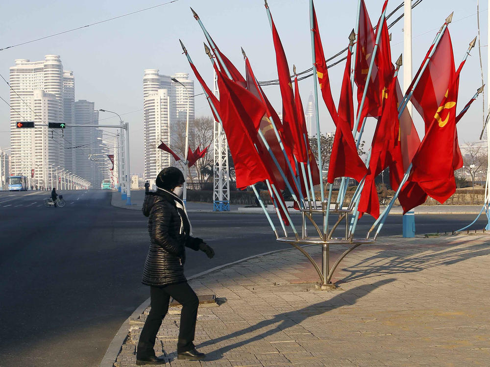 A person passes by a bouquet of Workers Party flags along a main street of the Central District in Pyongyang, North Korea, last week.