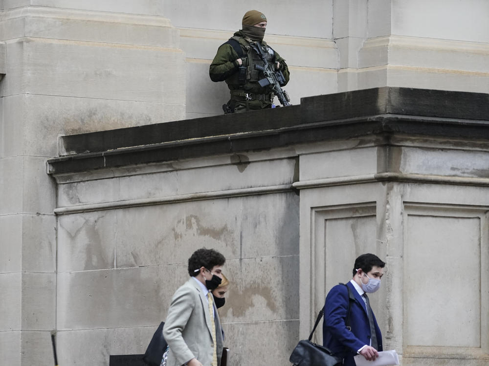 A member of the Georgia State Patrol SWAT team looks on as people walk by outside of the Georgia State Capitol after the opening day of the legislative session on Monday in Atlanta. State capitols across the country are under heightened security after the siege of the U.S. Capitol last week.