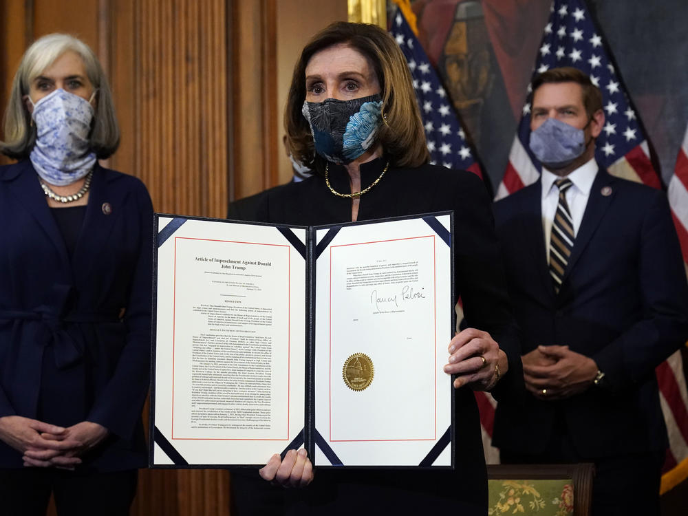 House Speaker Nancy Pelosi of California displays the signed article of impeachment against President Trump in an engrossment ceremony before transmission to the Senate for trial on Capitol Hill. It's unclear when a Senate trial will start.