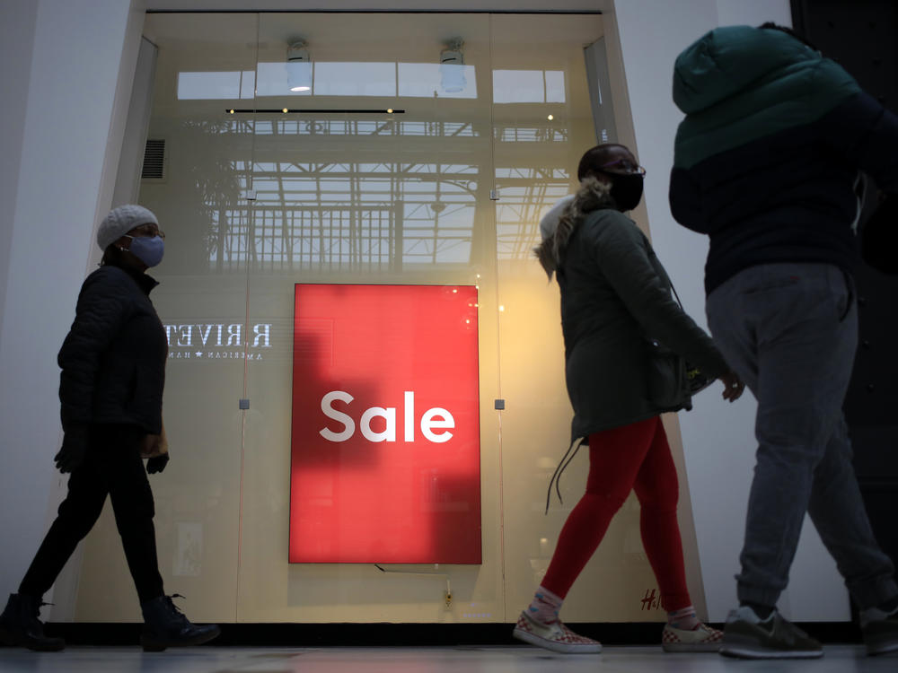 Shoppers walk past a 