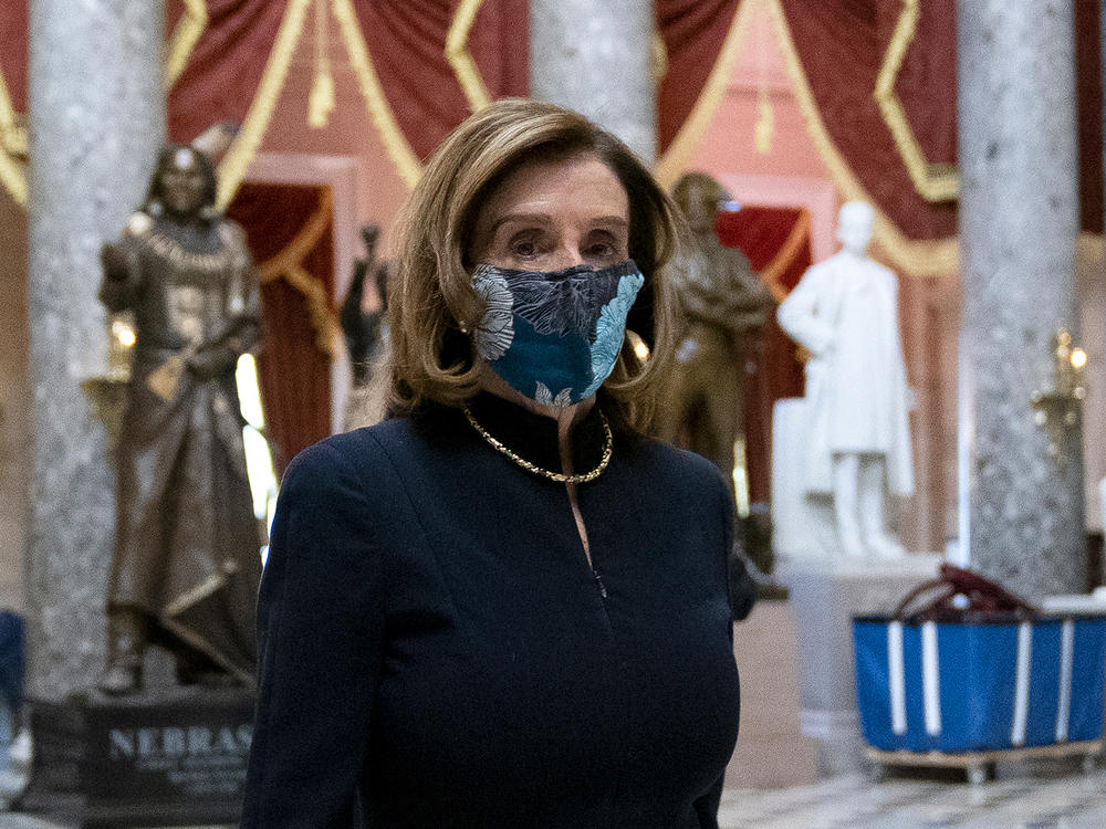 Speaker of the House Nancy Pelosi wears a protective mask while walking to her office from the House Floor on Wednesday.
