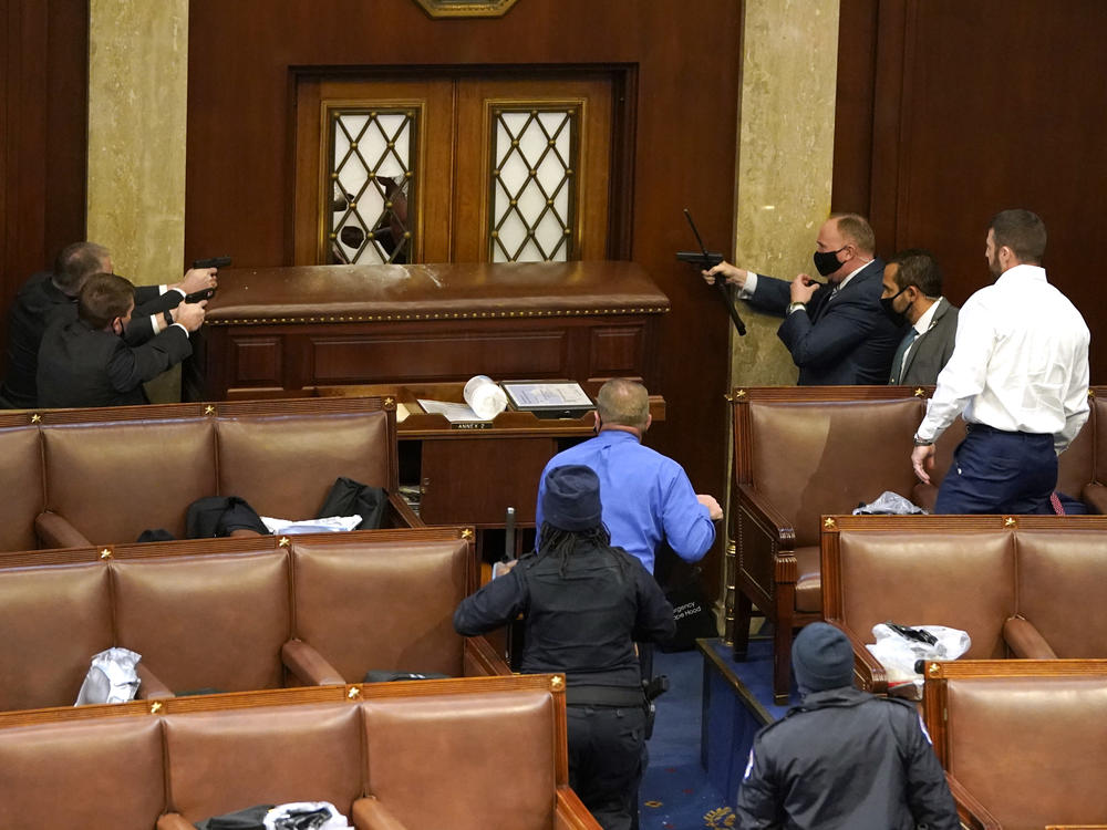 U.S. Capitol police point guns at a door in the House Chamber on January 6.