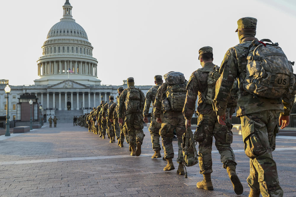 Members of the National Guard arrive at the U.S. Capitol this week to assist with security ahead of President-elect Joe Biden's inauguration. A new poll finds 58% of Americans think President Trump is to blame for last week's violence.