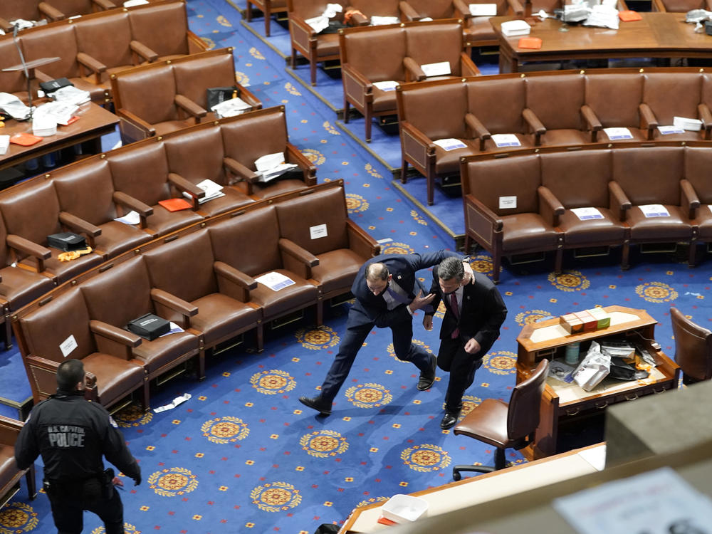 Members of Congress run for cover as rioters try to enter the House chamber on Jan. 6.