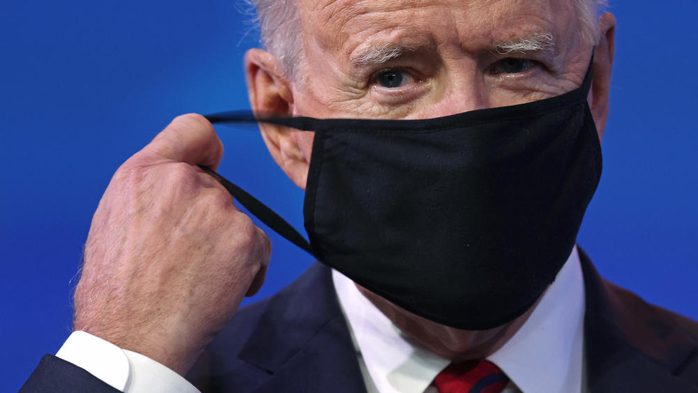 President-elect Joe Biden takes off his mask before laying out his proposal for a $1.9 trillion coronavirus relief package on Jan. 14.