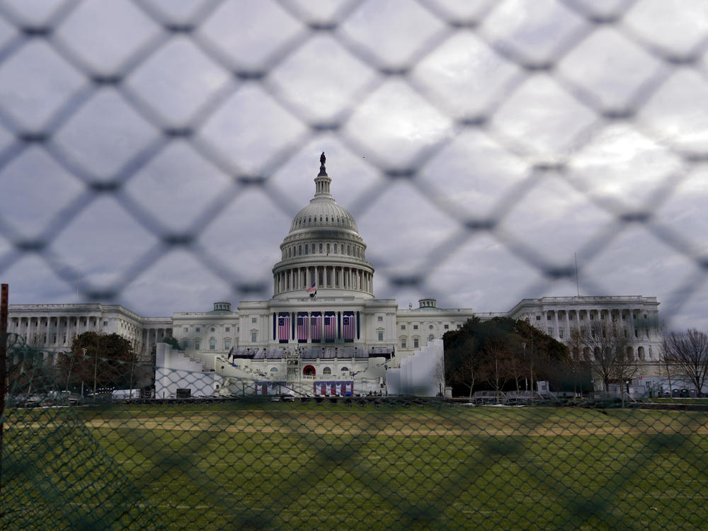 The U.S. Capitol is seen behind fences on Sunday, following the violent riot by pro-Trump extremists on Jan. 6. This week's events will have the largest security presence of any inauguration in U.S. history.