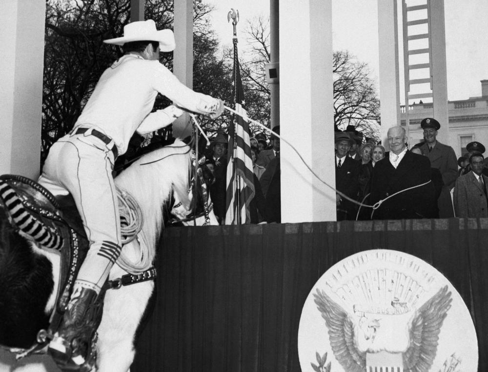 President Dwight D. Eisenhower (center) gets lassoed by Montie Montana in the presidential stand in front of the White House during the inaugural parade, Jan. 20, 1953.