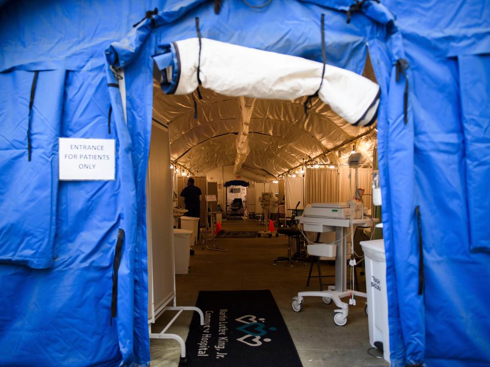 A field hospital tent for suspected COVID-19 patient triage was set up outside the emergency department of Martin Luther King Jr. Community Hospital in Los Angeles, California. A surge in deaths has prompted the county to lift environmental limits on the number of cremations that can be performed each month.