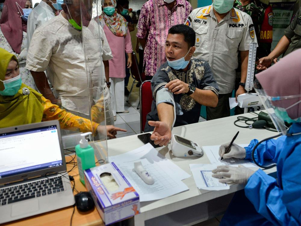 An official has a blood pressure test before receiving the Sinovac coronavirus vaccine, developed in China, at a hospital in Banda Aceh, Indonesia, on January 15.