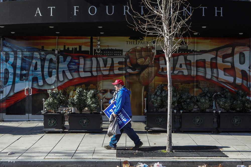 Joe Brunner, a supporter of former President Donald Trump, walks by a Black Lives Matter and George Floyd mural in Washington, D.C., on Wednesday.