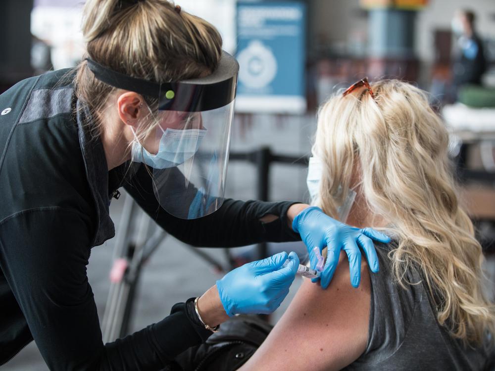 A woman receives the COVID-19 vaccine last week at Gillette Stadium in Foxborough, Mass. Setting up community vaccination centers will be a key to getting the vaccine to millions, an adviser to President Biden says.