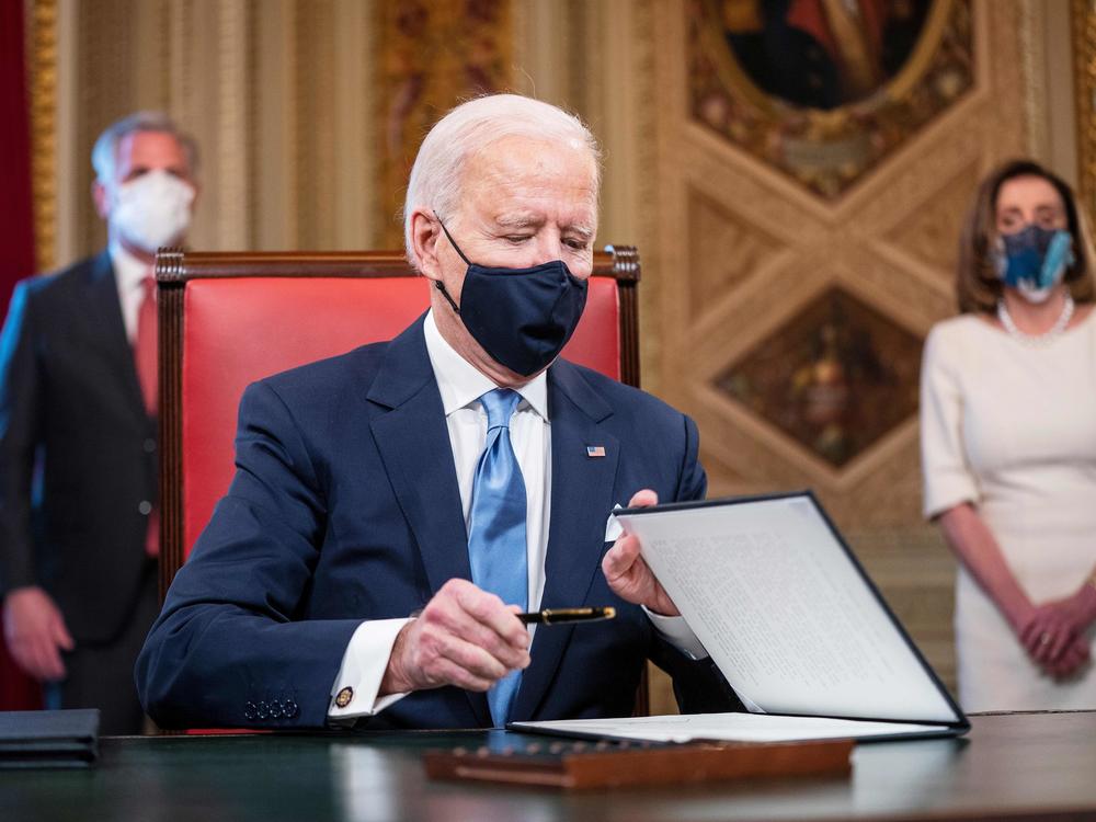 President Biden signs documents in the Presidents Room at the U.S. Capitol after taking the oath of office.