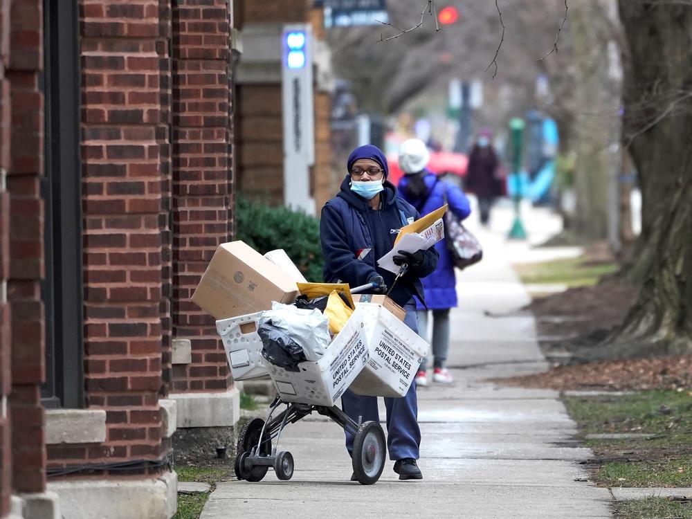 A U.S. postal worker delivers packages, boxes and letters in Chicago's Hyde Park neighborhood shortly before Christmas. The U.S. Postal Service said it faces 
