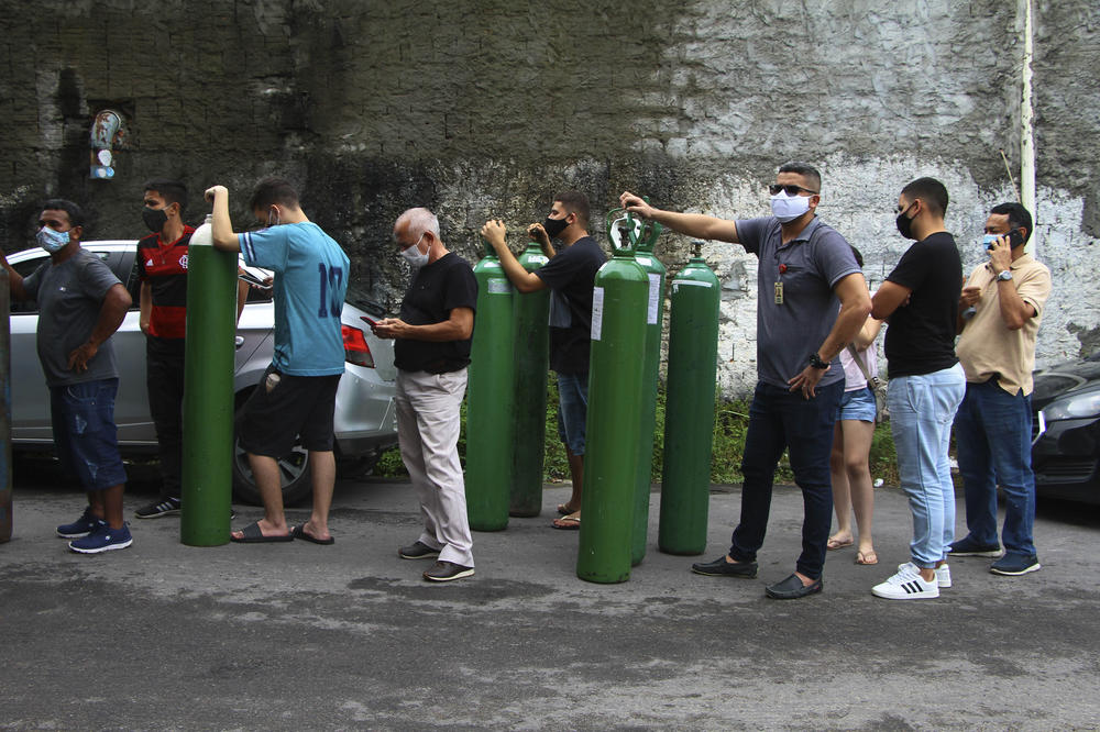 Relatives of patients hospitalized with COVID-19 line up to refill empty oxygen tanks outside the Nitron da Amazônia company, in Manaus, Amazonas state, Brazil, on Jan. 15.