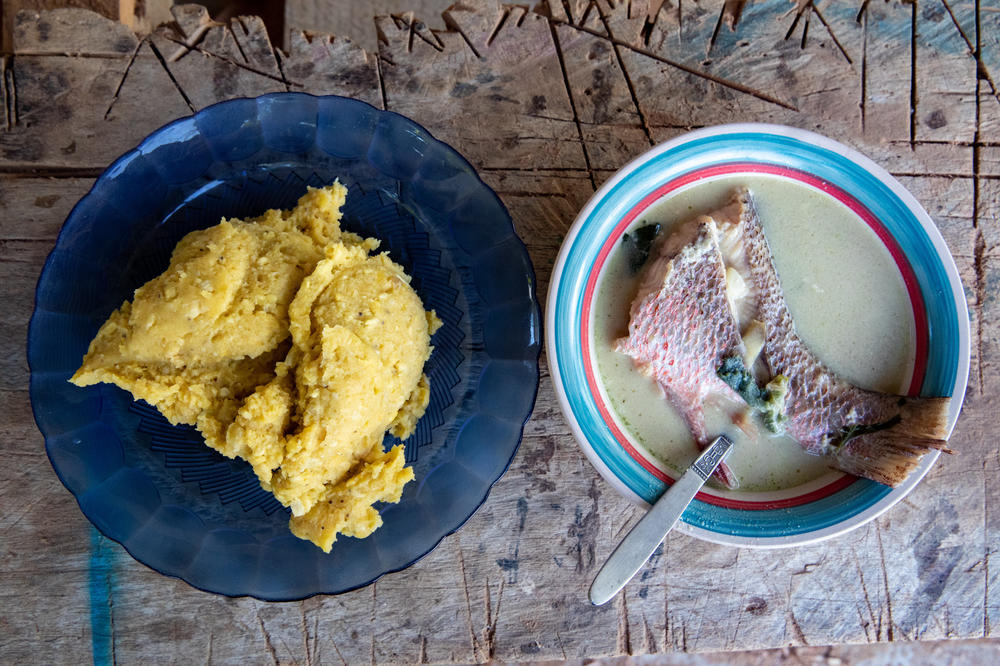A plate of <em>machuca</em>, boiled and mashed plantains, next to a basil coconut soup with red snapper. Family matriarch Tomasa Guity prepared the food for the family's Sunday meal.