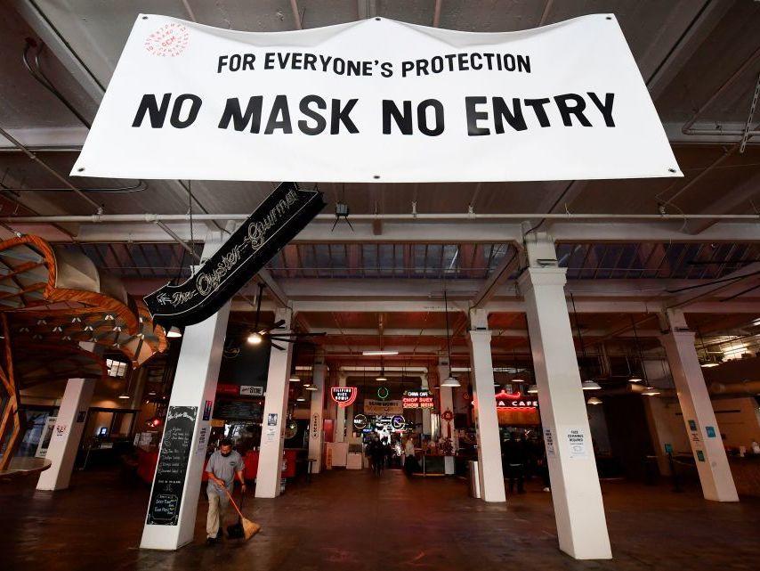 A sign reminds people to wear face masks at an empty Grand Central Market in November in Los Angeles. The city has urged residents to stay home since early December to slow its outbreak.